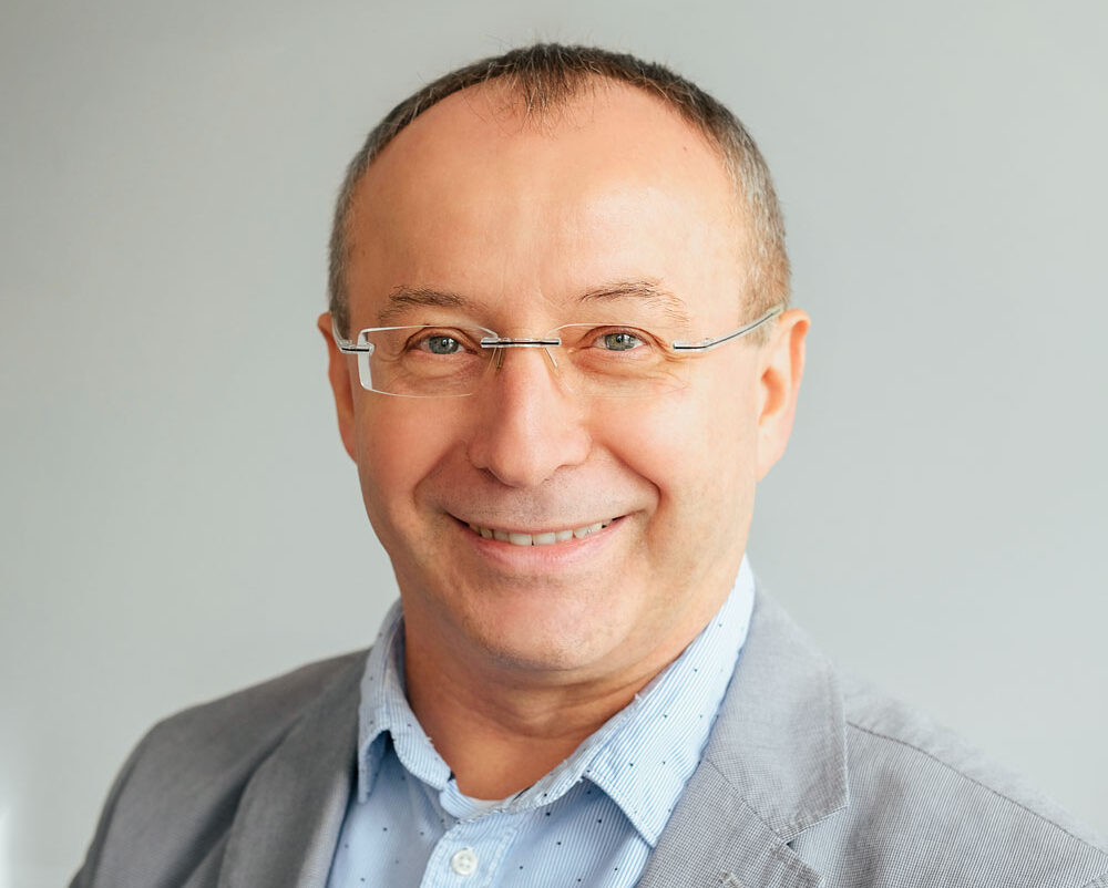 Portraitbild von Janusz Cisowski, Vorstand der softecture AG, in einem grauen Blazer